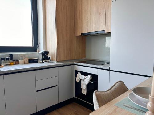 a kitchen with white cabinets and a stove top oven at V'One - Cozy & Quiet Apartment - Free Parking in Timişoara