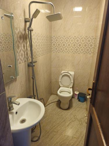 a bathroom with a toilet and a sink at Oscar Hotel Guba in Quba