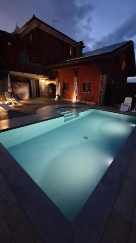 a large swimming pool in a backyard at night at Villa Laura B&B in Fossano