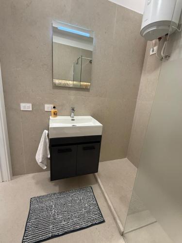 a bathroom with a sink and a mirror at La Vista Suite and Rooms in Ladispoli
