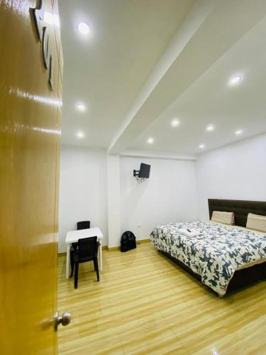 a bedroom with a bed and a table and a desk at Hurin Perú in Ica