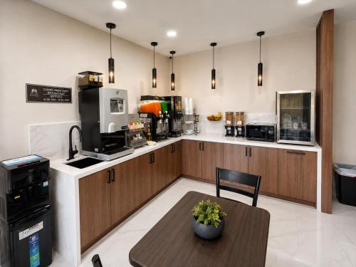a kitchen with a table and a counter top at Hotel Royale - Houston Hobby Airport in Houston