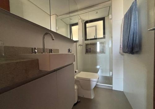 a bathroom with a toilet and a sink and a mirror at Alojamiento Center in Barraquero