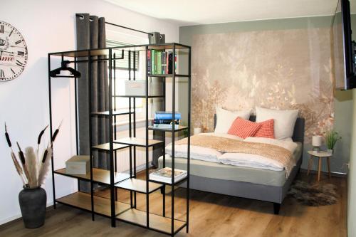 a black book shelf next to a bed in a room at Apartment -Zur Oehla in Ilmenau