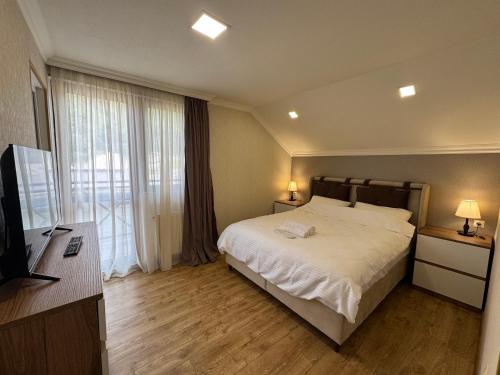 a bedroom with a bed and a large window at Villa Kazbegi in Tkarsheti