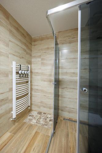 a shower in a bathroom with wooden walls at Moto pub Marusja in Snina
