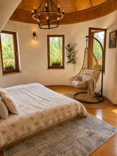 a bedroom with a bed and a chair and windows at Weekend house Grahovača in Rožaje
