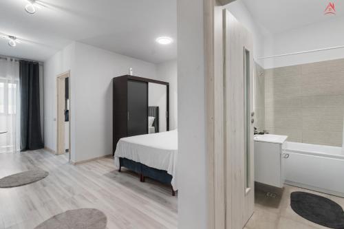 a bedroom with a bed and a bathroom with a sink at Crina Studio in Bragadiru