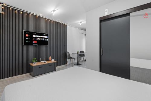 a room with a bed and a tv on a wall at Crina Studio in Bragadiru