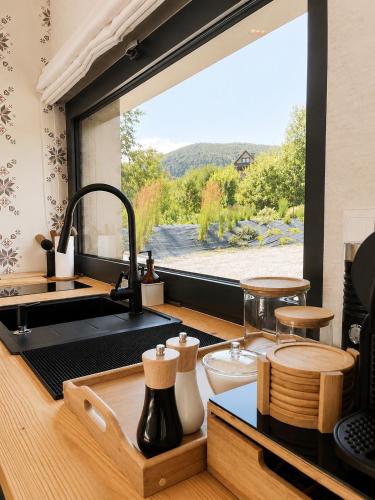 a kitchen with a sink and a large window at Krzywe Pearl Chalets in Krywe