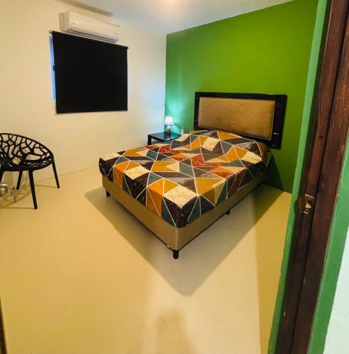 a bedroom with a bed and a green wall at sol appartement 3 in Willemstad