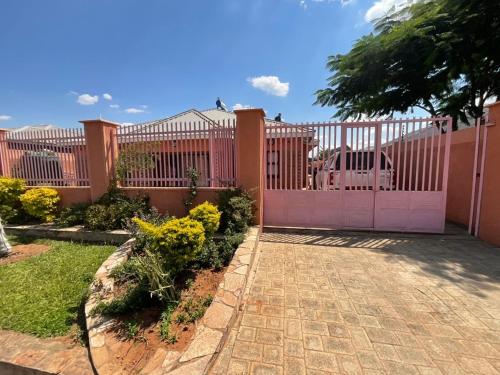 a fence with a pink gate in a yard at Zahara Lodge in Victoria Falls
