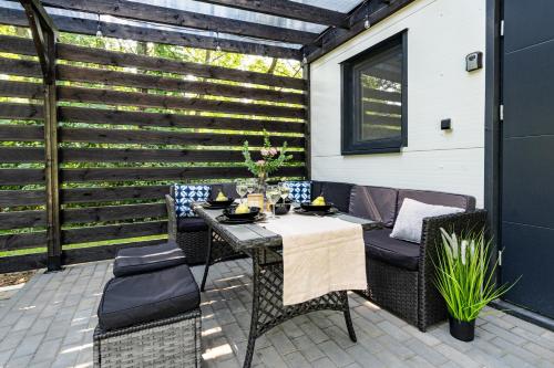 a patio with a table and chairs and a wooden wall at Ale Jazz w cenie jacuzzi i basen in Nowe Miasto