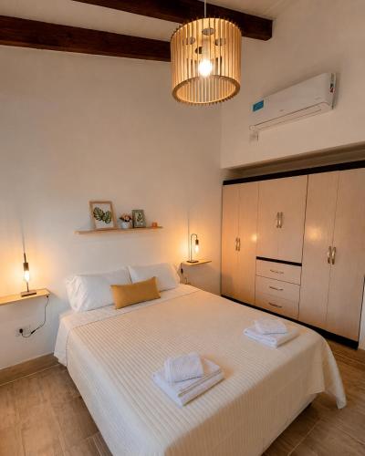 a bedroom with a large white bed with two towels at Casa de los Cerros II in Vaqueros