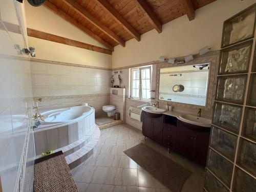 a bathroom with a tub and a sink and a toilet at Luxury Villa near Vila Sol Golf Resort - Pool & Garden in Quarteira