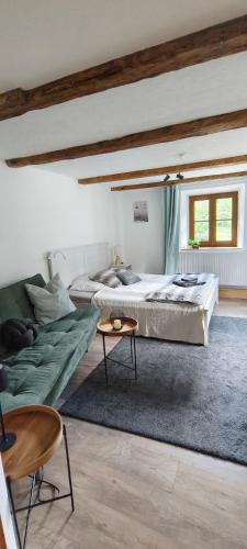 a bedroom with a bed and a couch and a table at Haus am Seebach Leutasch Weidach in Leutasch