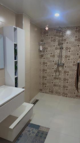 a bathroom with a shower and a white sink at Ayden Residence Béjaïa in Bejaïa