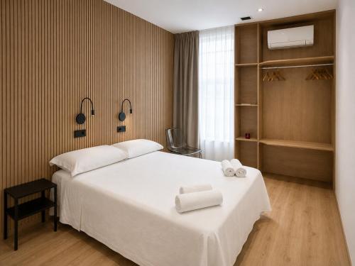 a bedroom with a bed with two towels on it at Welcome Hostel in Churriana