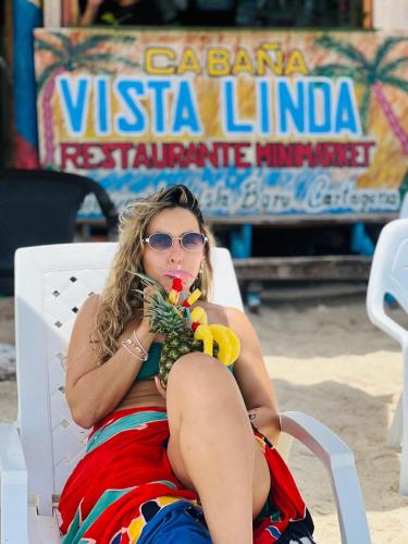 a woman sitting in a chair talking on a cell phone at Vista Linda Cabaña in Playa Blanca