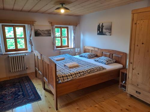 a bedroom with a bed and two windows at Sudetský grunt Autentická jesenická chalupa in Loučná nad Desnou