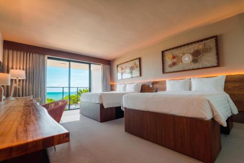 a hotel room with two beds and a large window at Tauá Hotel e Convention João pessoa in João Pessoa
