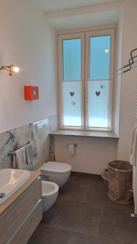 a bathroom with a toilet and a sink and a window at B&B MAST Apartment Suite in San Pellegrino Terme