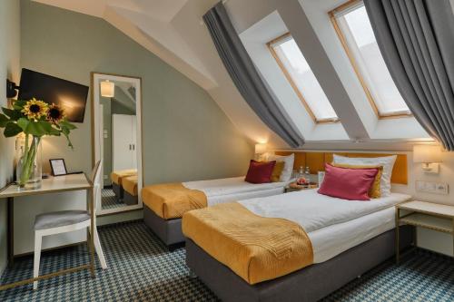 two beds in a hotel room with windows at Hotel Villa Art Novis Wrocław Centrum in Wrocław