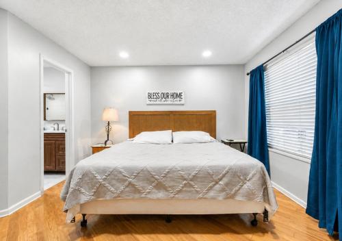 a bedroom with a bed and a window with blue drapes at 3697 Orlando Vacational Apartment in Orlando