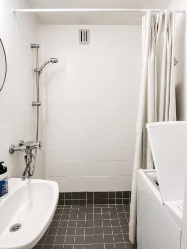 a white bathroom with a sink and a shower at Galle's 2 bedroom penthouse in Pori