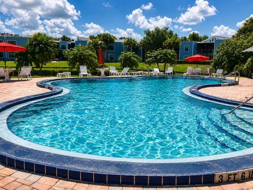 a swimming pool at a resort with chairs and umbrellas at 3697 Orlando Vacational Apartment in Orlando
