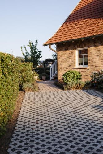 ein Haus mit einem gemauerten Gehweg neben einem Gebäude in der Unterkunft Schöne Lage in Lage