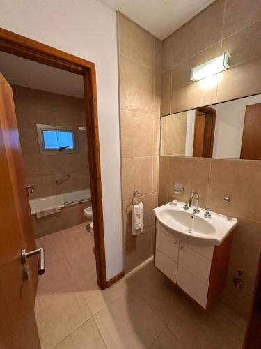 a bathroom with a sink and a mirror and a toilet at Complejo Totoras in Pinamar