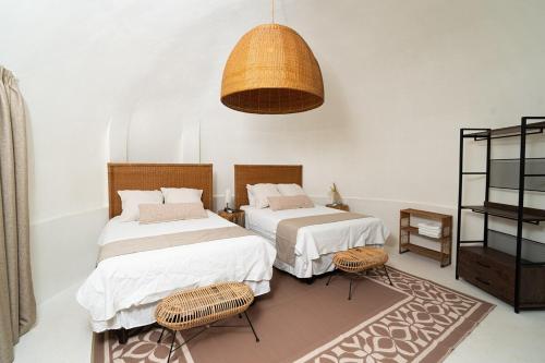a bedroom with two beds and a pendant light at Casa Sofia 19 Guests, Steps From The Sea in Tela