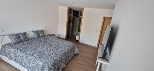 ein Schlafzimmer mit Bett und Flachbildfernseher in der Unterkunft vila pico de regalados in Vila Verde