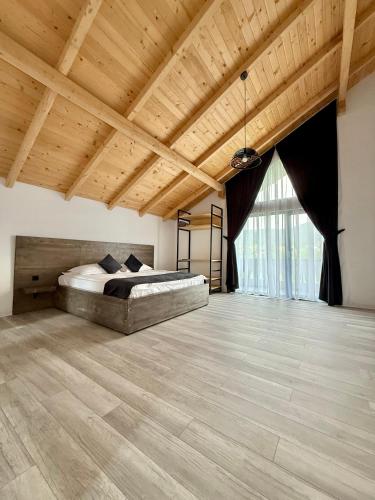 a large bedroom with a bed and a wooden ceiling at Austrian Villa's in Covasna