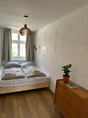 a bedroom with a bed and a dresser and a window at Wohnen am Prenzlauer Tor in Pasewalk