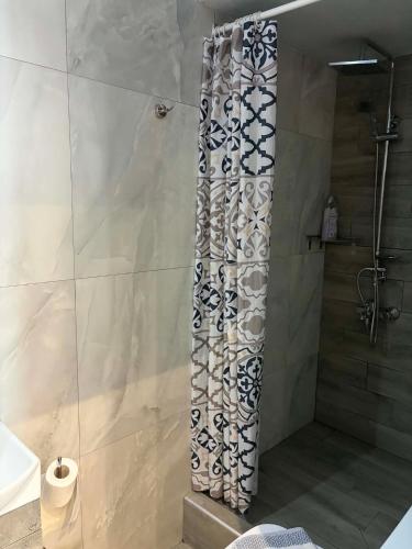a shower with a shower curtain in a bathroom at Greysuites in Kavála