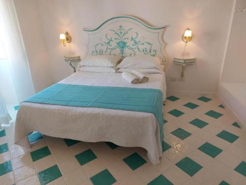 a bedroom with a bed with a blue and green bedspread at Pensione Maria Luisa in Positano