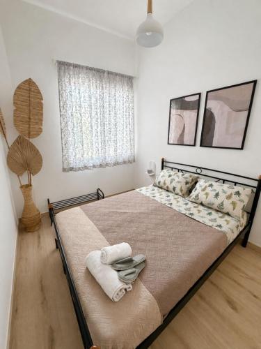 a bedroom with a large bed with towels on it at Oasis Pool Flat-near 2 metro stations- in Piraeus