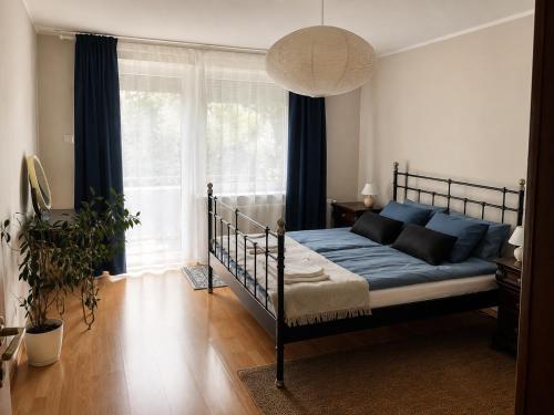 a bedroom with a bed and a large window at Nine to Trail Apartment in Wielka Wieś