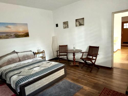 a bedroom with a bed and a table and chairs at Chata Białobrzeg in Białobrzeg Dalszy