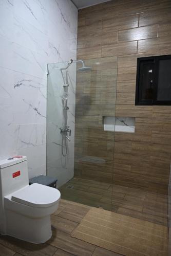 a bathroom with a toilet and a glass shower at villa serenity in Jarabacoa
