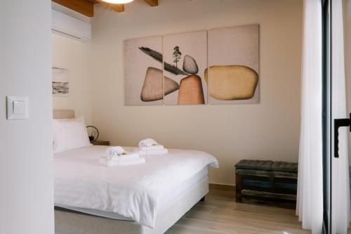 a bedroom with a bed with two towels on it at Odysseas Seaside Escape by Philoxenia in Artemida