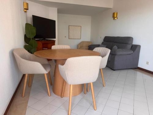 a living room with a table and chairs and a couch at Vilamoura Marina Beach Apartament in Quarteira