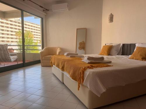 a bedroom with a large bed and a balcony at Vilamoura Marina Beach Apartament in Quarteira