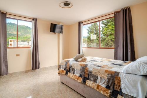 a bedroom with a bed and a large window at Downtown Apartment, Sierra Nevada 3 in Ibarra