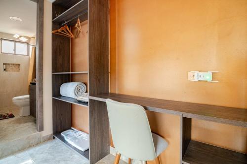 a white chair sitting in a room with a closet at Downtown Apartment, Sierra Nevada 3 in Ibarra