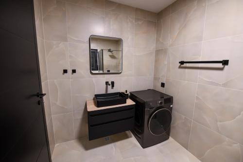 a bathroom with a washing machine and a mirror at Luxury Villa with a Private Pool in Hadžići