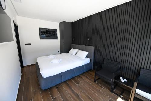 a small bedroom with a bed and a chair at Luxury Villa with a Private Pool in Hadžići