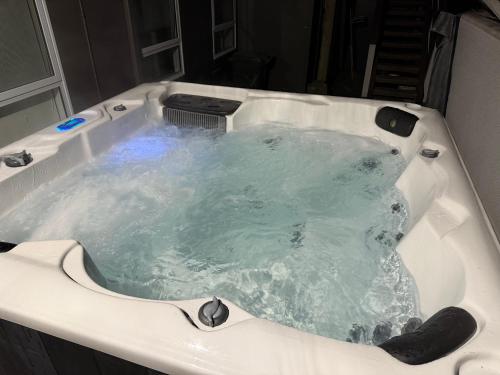 a jacuzzi bathtub filled with green water at Ohope Coastal Escape in Ohope Beach